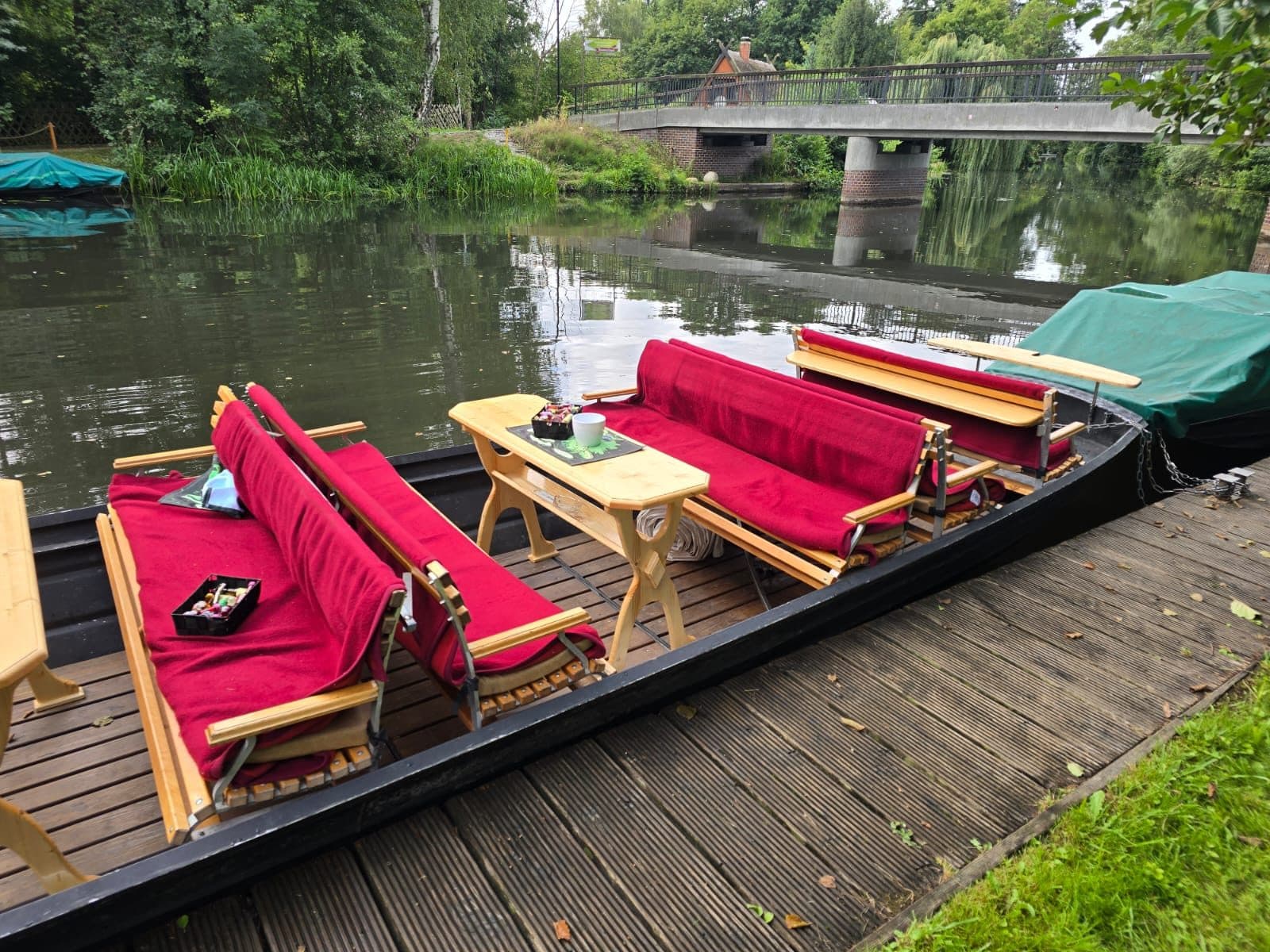 Gepolsterte Bänke und Tisch im Kahn, dahinter die Brücke